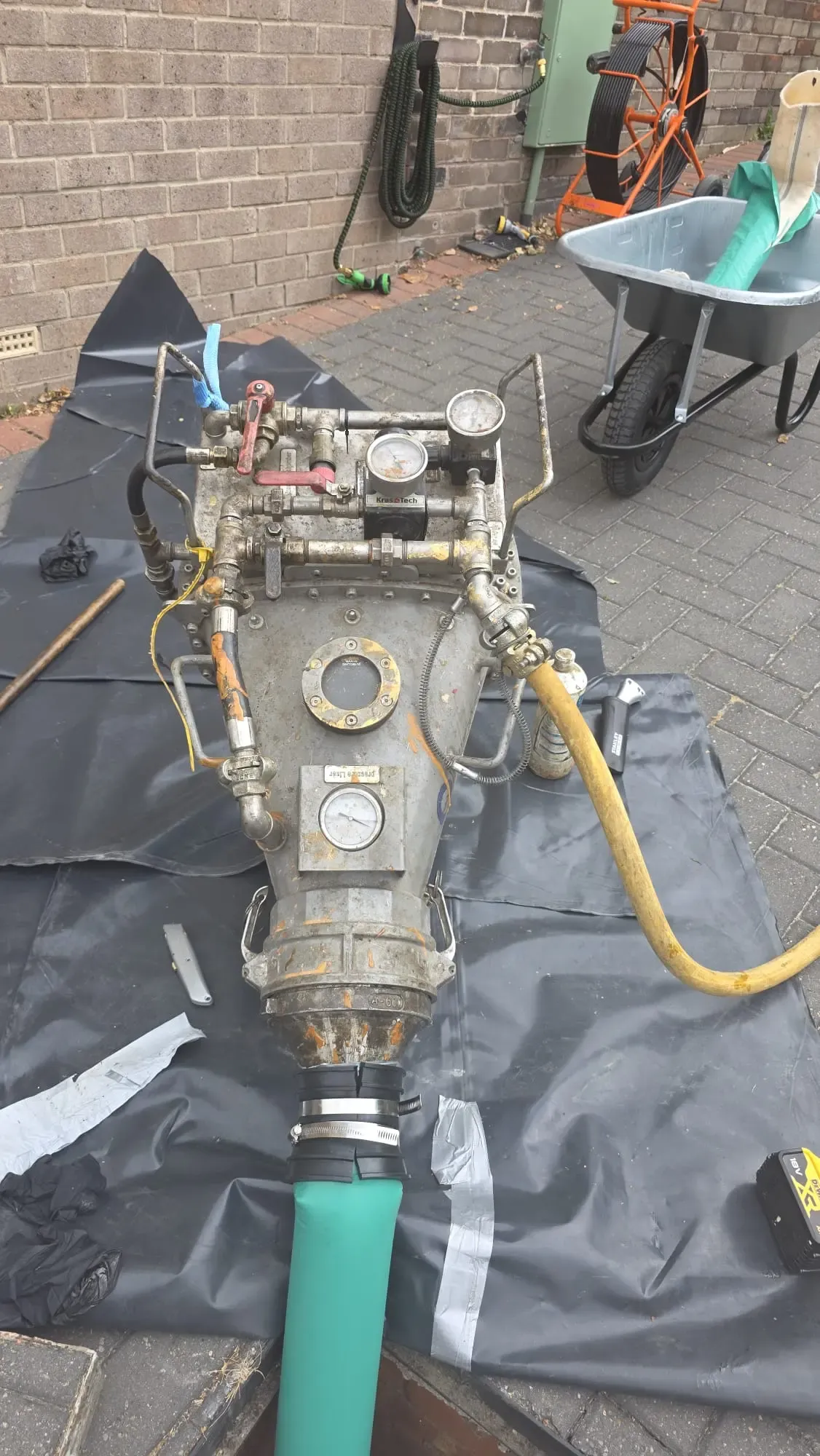 Specialist CIPP inversion drum equipment set up for no-dig drain relining on a block-paved driveway.